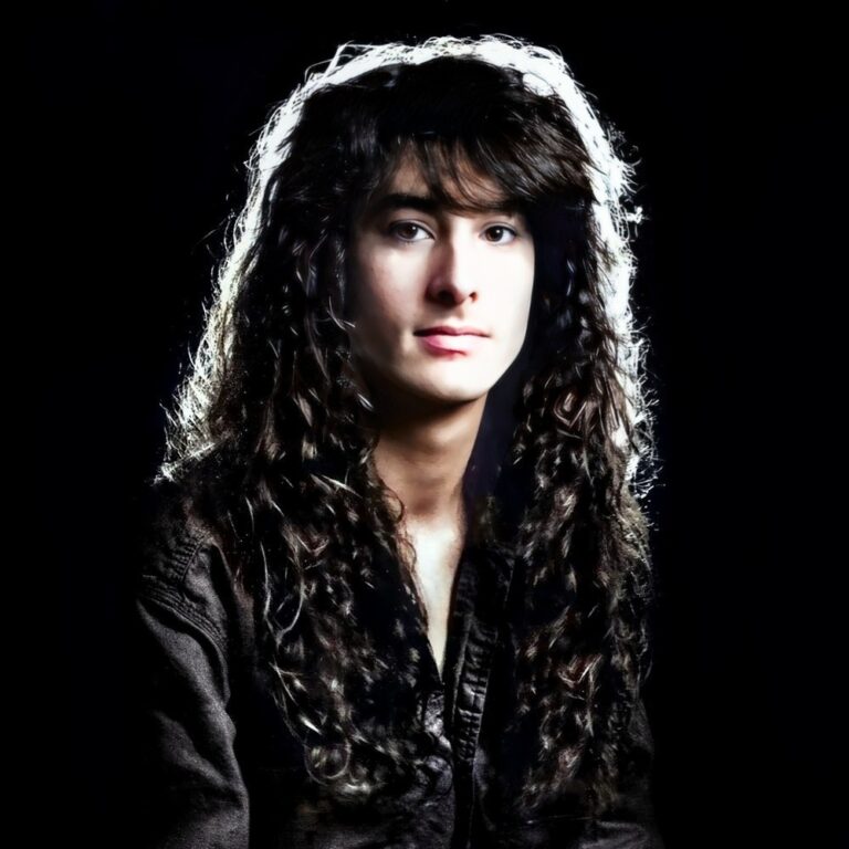 hairdresser Tom Zappala sitting in his Melbourne natural hair salon with long curly hair